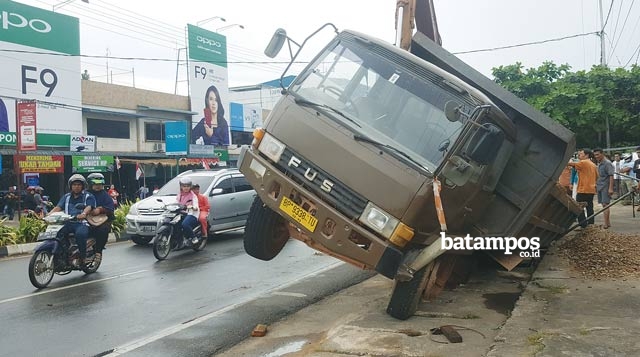 Roda Truk Pasir Masuk Drainase Saat Parkir di Tepi Jalan