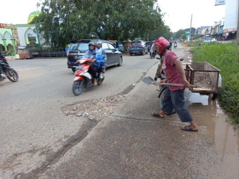 Tak Kunjung Diperbaiki, Warga Timbun Jalan Rusak dengan Puing Bangunan